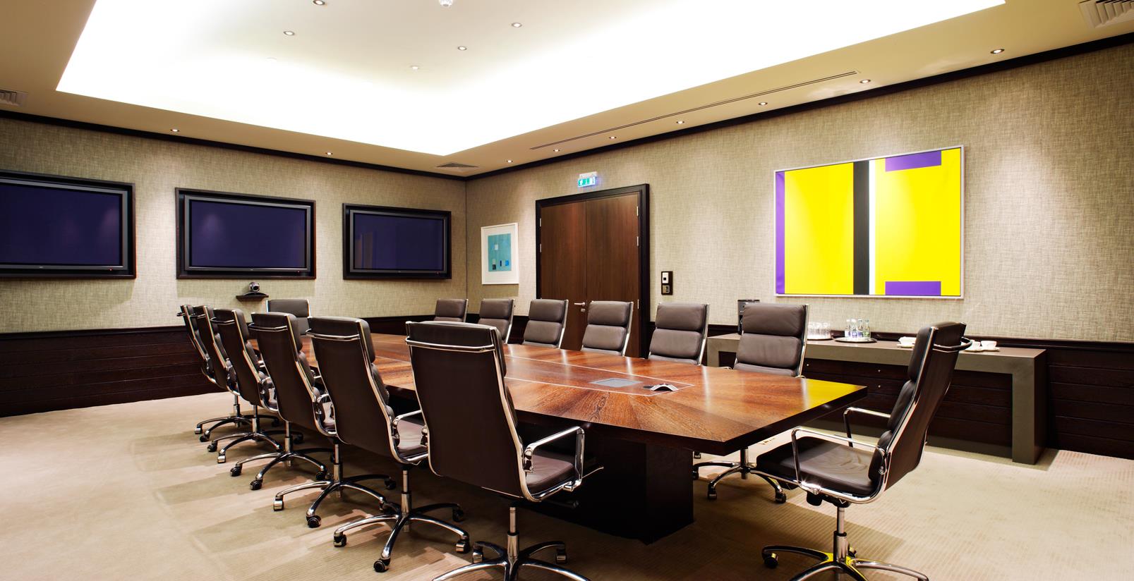 Hochwertige Büroeinrichtung mit massivem Holztisch und Lederstühlen im Konferenzraum