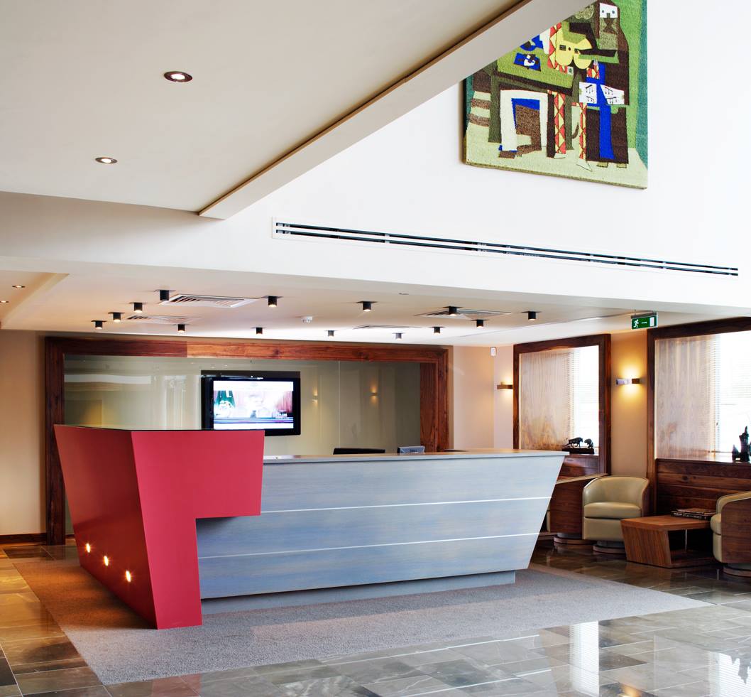 Empfangstheke in U-Form konisch mit abgesetztem, erhöhtem roten Bereich